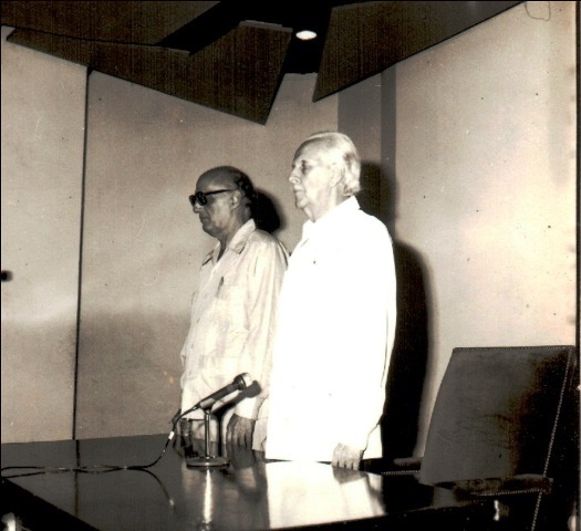 Foto de Le Riverend  y Portuondo entonan las notas del Himno de Bayamo. Sala teatro de la Biblioteca Nacional, 13 septiembre de 1982. Fondos BNCJM.  